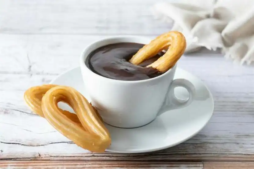 traditional spanish churros with hot chocolate breakfast wooden table2